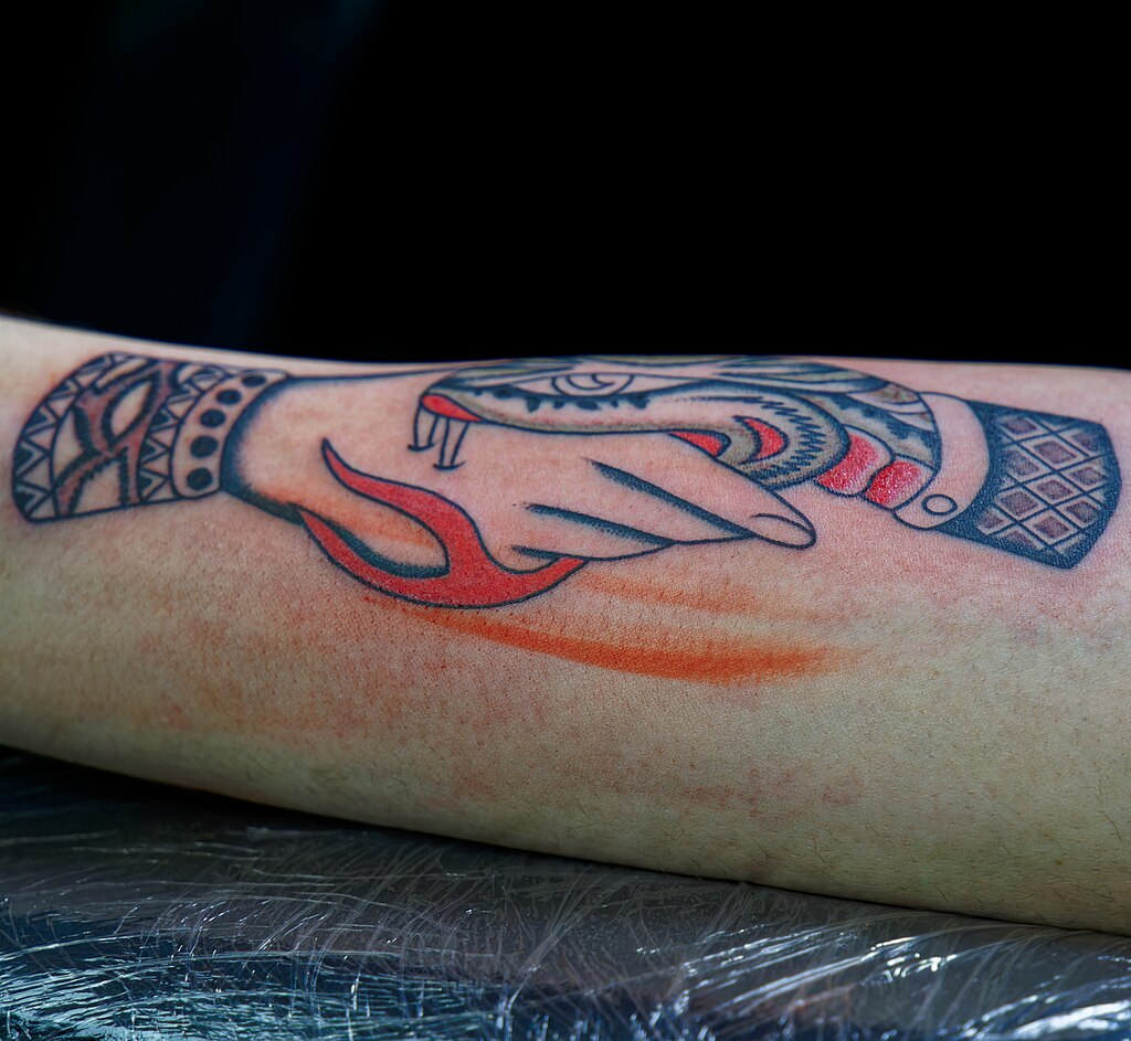 Tattoo_of_snake_biting_a_hand_at_the_International_Brussels_Tattoo_Convention_2023